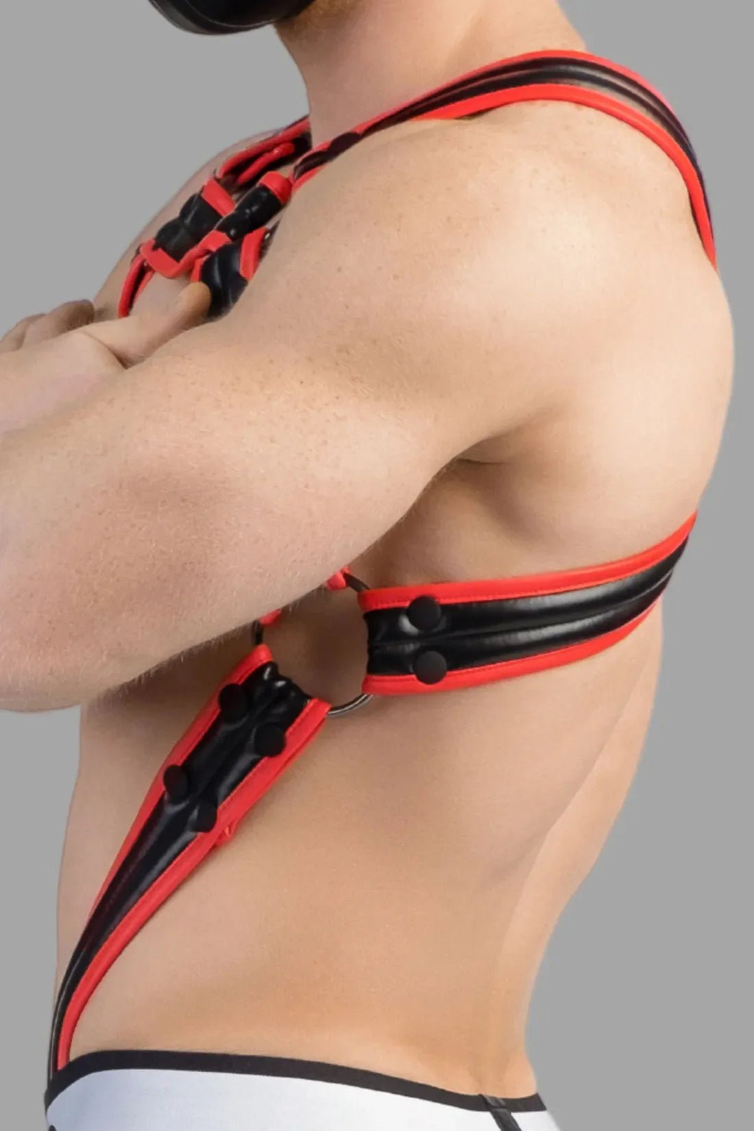 Maskulo Armored Next black and red body harness, featuring polyurethane/polyester blend, bulldog design with removable cockring, and adjustable snaps.