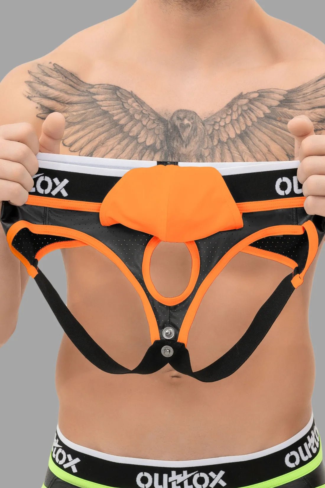 Outtox black and orange jockstrap with snap codpiece for men. Features perforated stretchable PU eco leather for comfort and style.